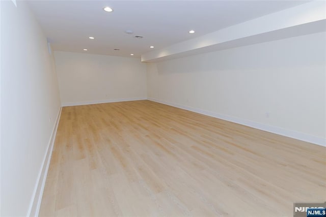 spare room featuring recessed lighting, light wood-style flooring, and baseboards