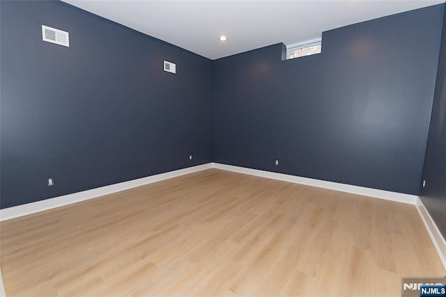 unfurnished room featuring baseboards, visible vents, and light wood-style flooring