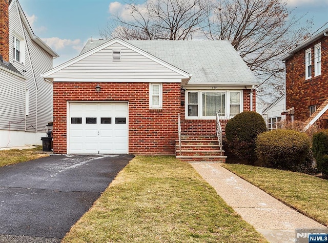 view of front facade with brick siding, a front lawn, an attached garage, and aphalt driveway