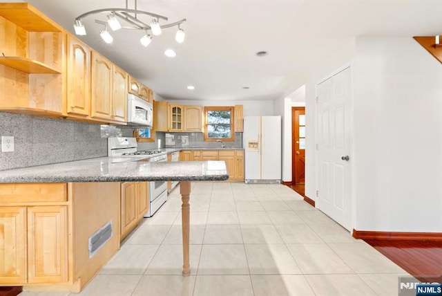 kitchen with decorative light fixtures, decorative backsplash, light tile patterned floors, kitchen peninsula, and white appliances