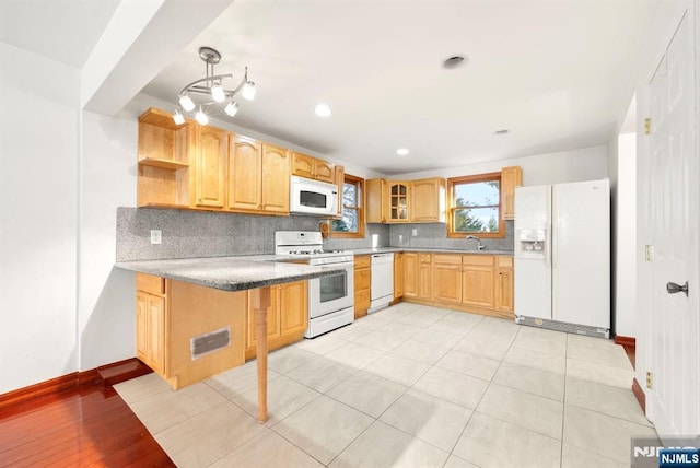 kitchen featuring sink, white appliances, light tile patterned floors, backsplash, and light brown cabinets