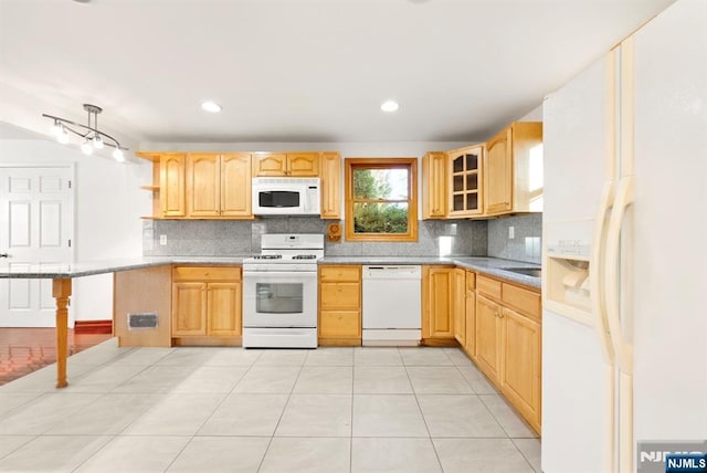 kitchen with light brown cabinets, a breakfast bar area, white appliances, and kitchen peninsula