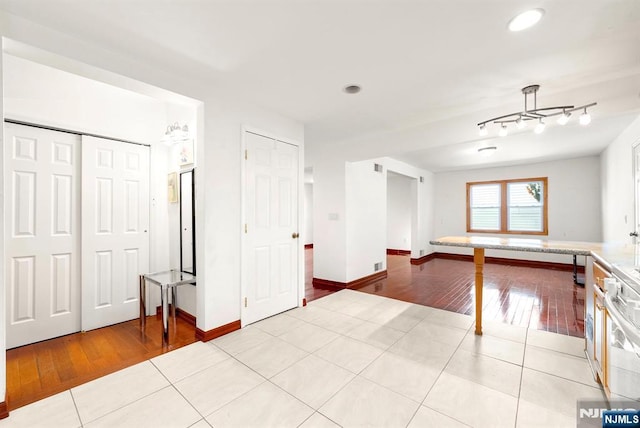 interior space featuring light tile patterned flooring, track lighting, and stove