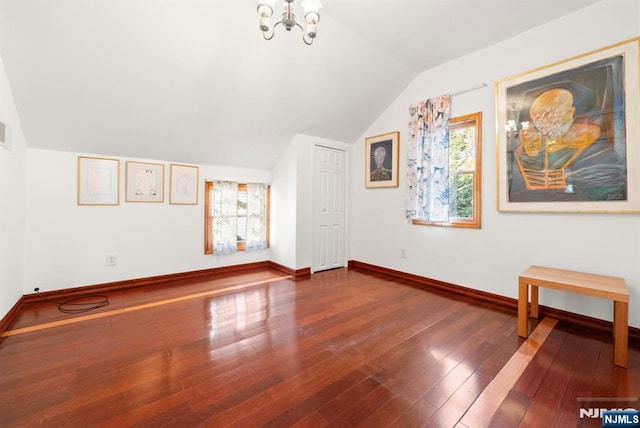 interior space with an inviting chandelier, lofted ceiling, and wood-type flooring