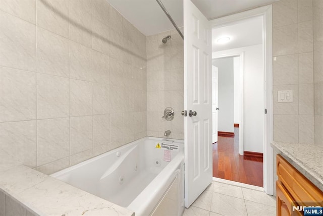 bathroom with tiled shower / bath, tile patterned floors, tile walls, and vanity