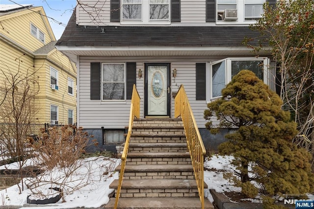 snow covered property entrance with cooling unit