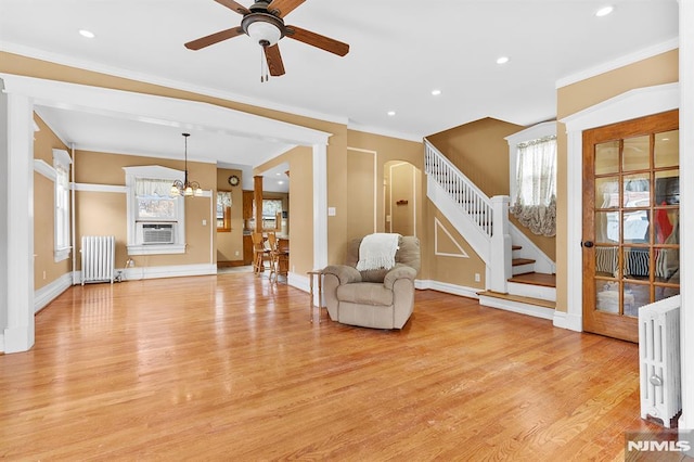 sitting room with crown molding, ceiling fan with notable chandelier, radiator heating unit, and light hardwood / wood-style flooring