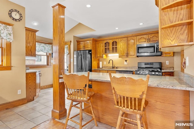 kitchen featuring appliances with stainless steel finishes, kitchen peninsula, and light stone countertops