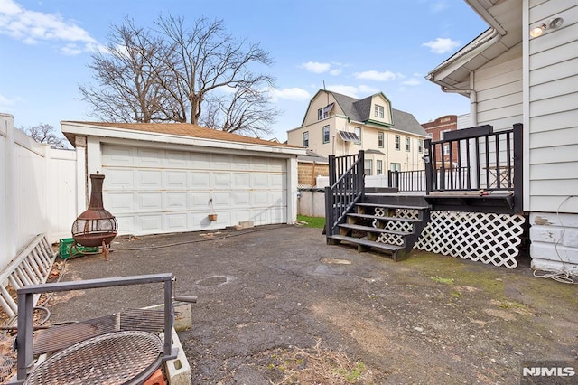 view of yard with a garage, an outbuilding, a deck, and an outdoor fire pit