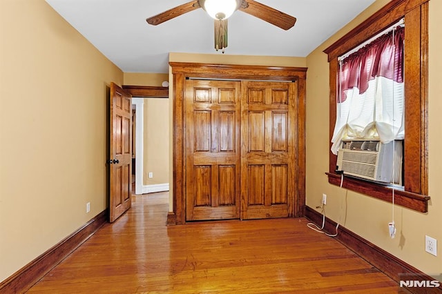 unfurnished bedroom with cooling unit, light hardwood / wood-style flooring, and ceiling fan