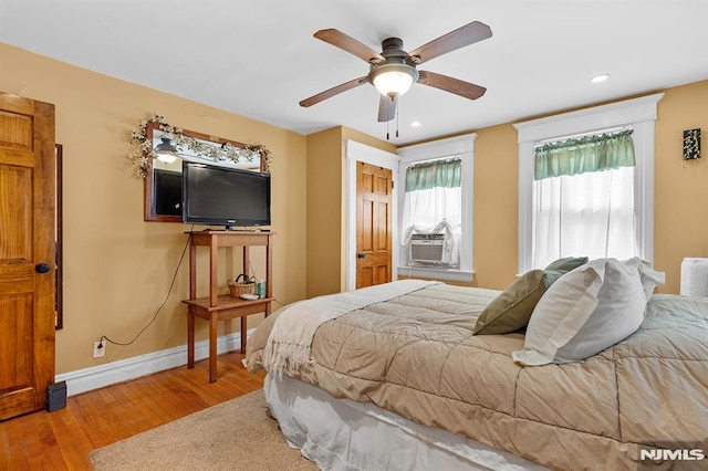 bedroom featuring cooling unit, ceiling fan, and hardwood / wood-style floors