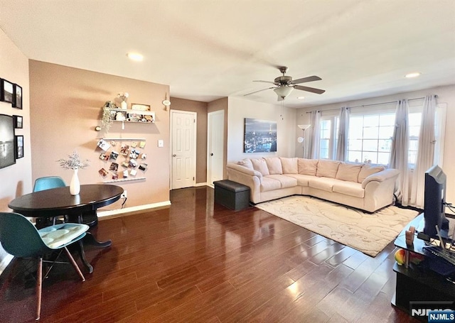 living room featuring ceiling fan and dark hardwood / wood-style flooring