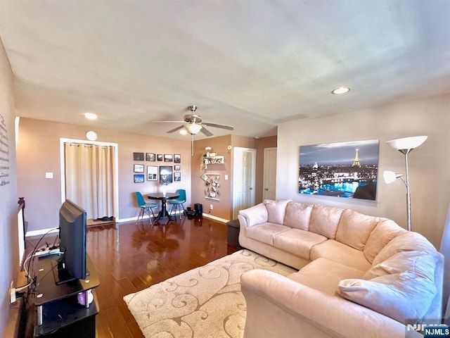 living room featuring dark hardwood / wood-style floors and ceiling fan