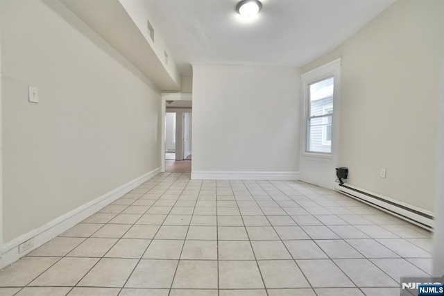 spare room featuring light tile patterned floors and a baseboard heating unit