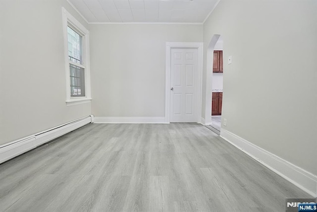 empty room with crown molding, baseboard heating, and light hardwood / wood-style flooring