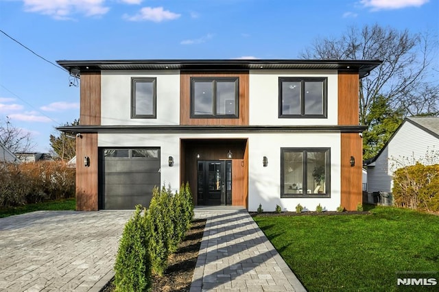 contemporary home featuring a garage and a front yard