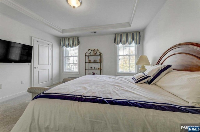 carpeted bedroom featuring crown molding and a tray ceiling