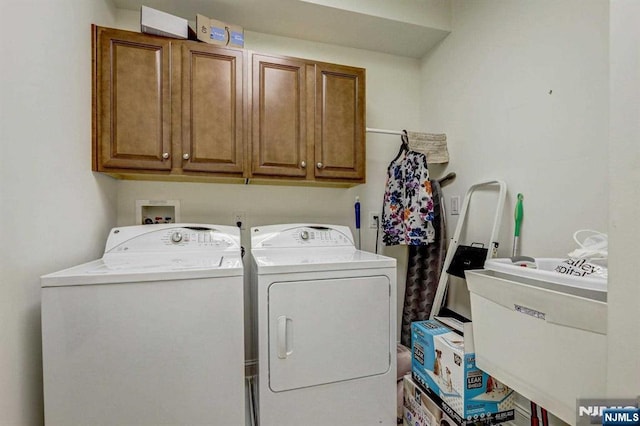 clothes washing area featuring cabinets, sink, and washer and dryer