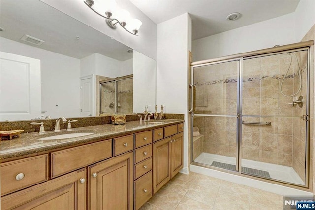 bathroom featuring tile patterned flooring, vanity, and walk in shower