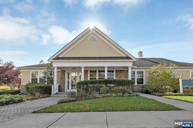 view of front of house with covered porch and a front yard