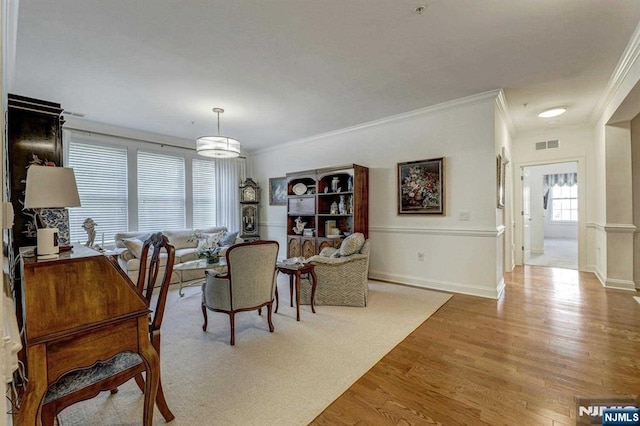 dining area with wood-type flooring and crown molding