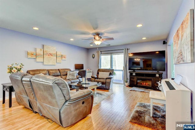 living room featuring ceiling fan and light hardwood / wood-style flooring