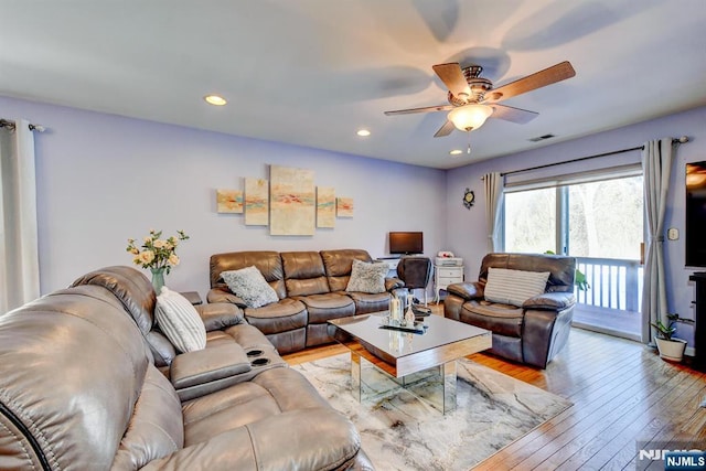 living room featuring light hardwood / wood-style flooring and ceiling fan