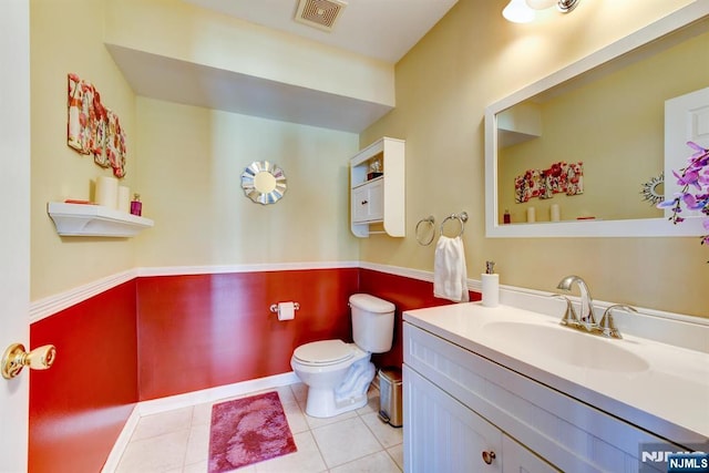 bathroom with tile patterned flooring, vanity, and toilet