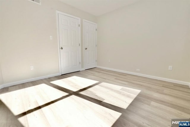 unfurnished bedroom with light wood-style floors and baseboards