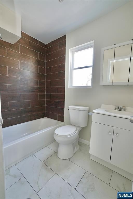 full bathroom with bathtub / shower combination, toilet, vanity, baseboards, and marble finish floor