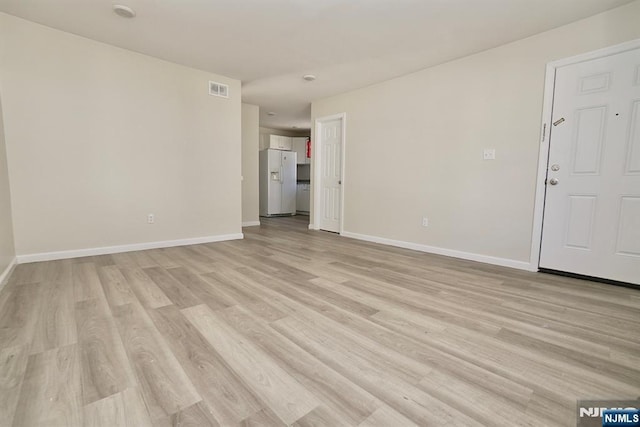 unfurnished living room with baseboards, visible vents, and light wood-style floors