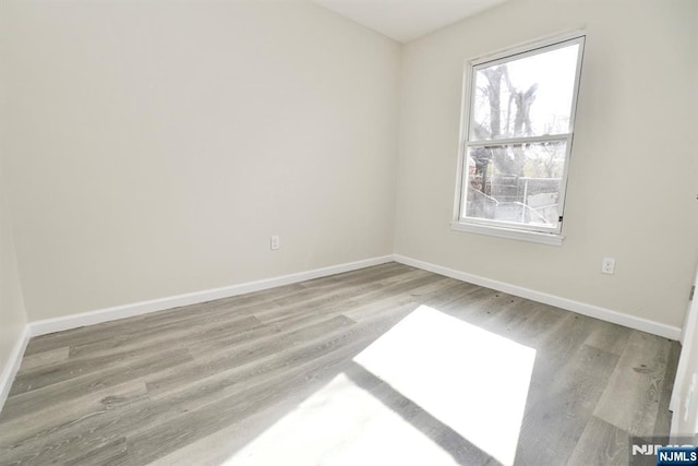 empty room with baseboards and light wood finished floors