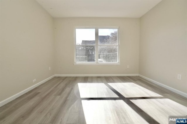 empty room with wood finished floors and baseboards