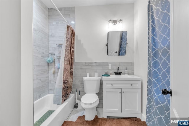 full bathroom featuring shower / tub combo, vanity, tile walls, and toilet