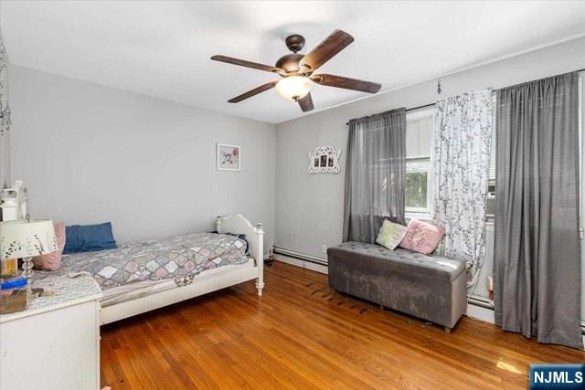 bedroom with wood-type flooring, ceiling fan, and baseboard heating