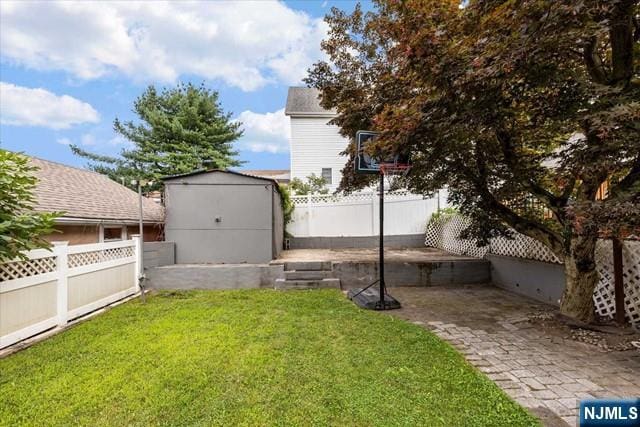 view of yard with a storage shed and a patio