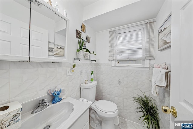 bathroom with vanity, tile walls, and toilet