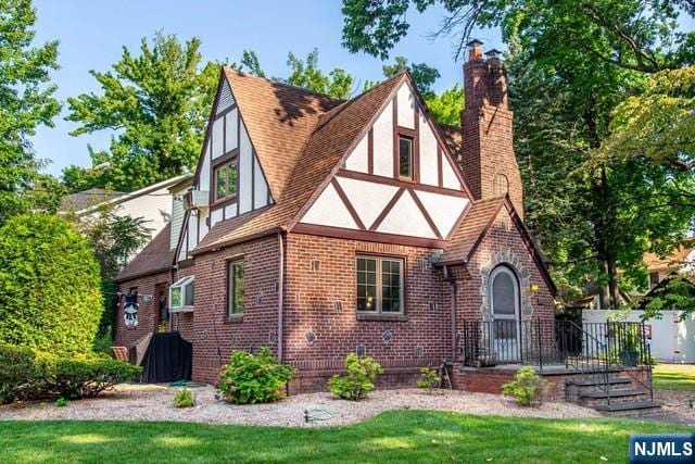 english style home with a front lawn