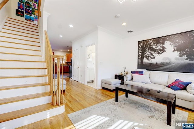 living room featuring wood-type flooring and ornamental molding