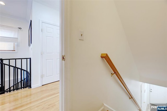 staircase featuring crown molding and hardwood / wood-style floors