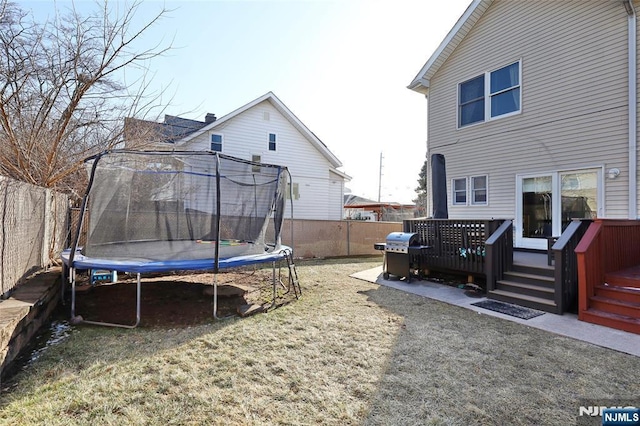 view of yard with a deck and a trampoline