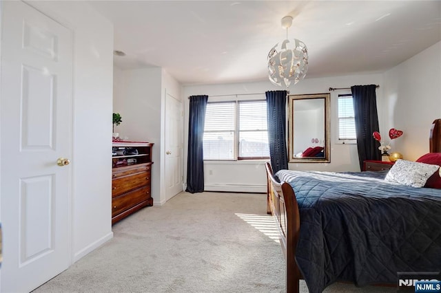 carpeted bedroom with a baseboard radiator and an inviting chandelier