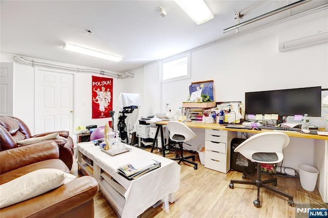 office with an AC wall unit and light wood-type flooring