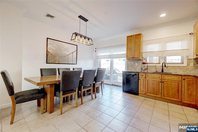 tiled dining area with sink, plenty of natural light, and ornamental molding