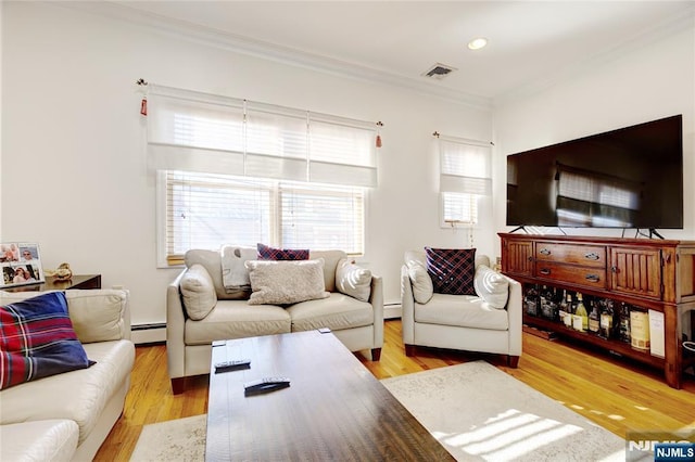 living room with baseboard heating, ornamental molding, and light wood-type flooring