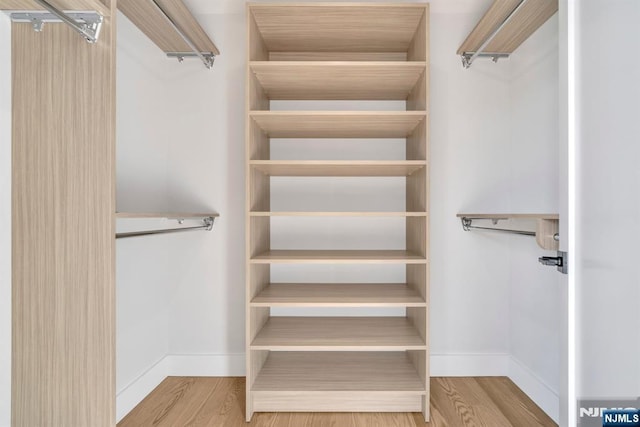 spacious closet with light hardwood / wood-style floors