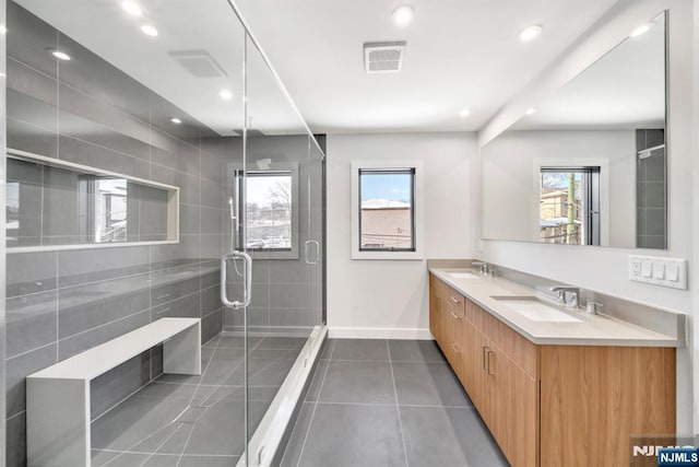 bathroom with vanity, tile patterned flooring, a shower with shower door, and a wealth of natural light