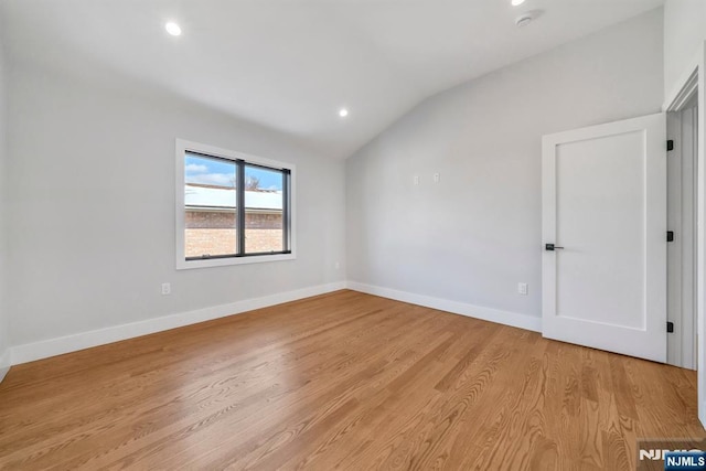 empty room featuring light wood-type flooring and lofted ceiling