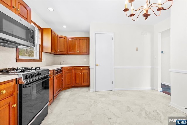 kitchen with stainless steel microwave, range with gas stovetop, brown cabinets, and light countertops