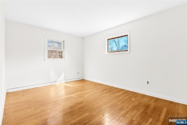 empty room featuring baseboards and wood-type flooring